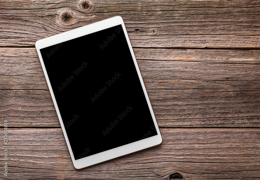 White tablet pc on old wood table background. White tablet pc on old wood table background.