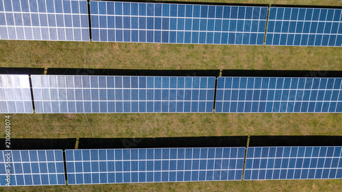 Aerial drone view of lines of solar panels in a field at a solar farm in South Wales, UK