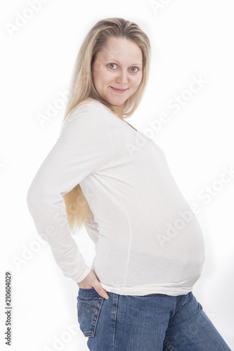 Child-Bearing Ideas and Concepts. Happy Pregnant Caucasian Woman Standing In White Shirt and Jeans Against Pure White Background.