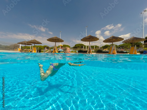 Young woman swimming undewater in the swimming pool