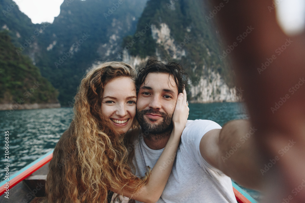 Couple taking selfie on a longtail boat - obrazy, fototapety, plakaty 