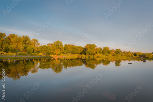 OTTAWA, ONTARIO / CANADA - JUNE 10 2018: TREES REFLECTION IN THE WATER IN THE MORNING.