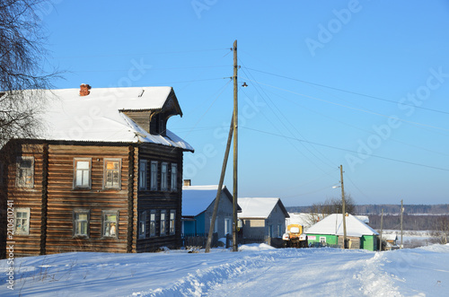 Russia, Arkhangelsk region, wooden buildings in the village Turchasovo inn winter in sunny weather photo