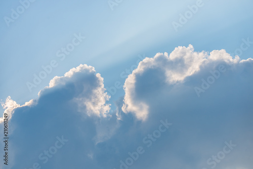 White clouds and blue sky with ray of sun coming through