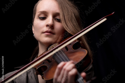 passionate violin musician playing on black background