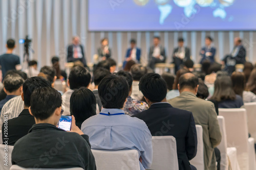 Rear view of Audience in the conference hall or seminar meeting which have Speakers on the stage, business and education about investment concept