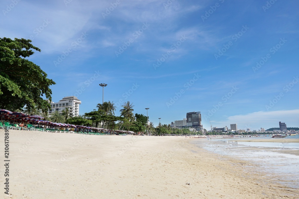 Blurred for background of Beach chairs with umbrella on beautiful beach and sea at Pattaya, Thailand. Seats on the sea beach, Summer holiday and vacation concept for tourism. abstract background.