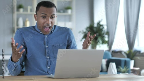 Loss, Frustrated Young African Man Working on Laptop photo