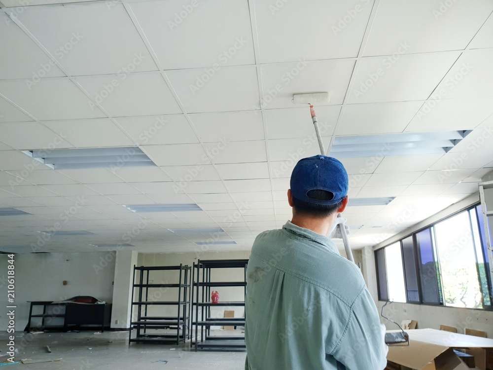 Close up of man at work painting a roof of new office, Copy space Close up of man at work painting a roof of new office, Copy space