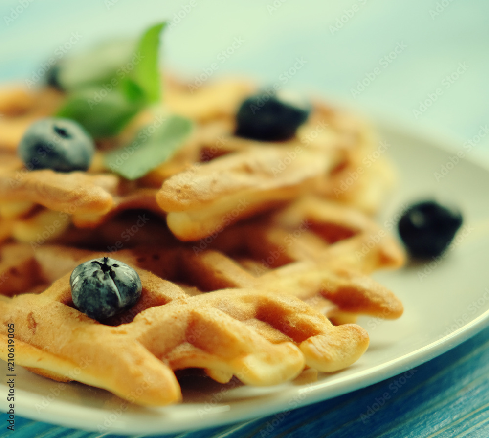 Homemade waffles with blueberries in plate on wooden table Homemade waffles with blueberries in plate on wooden table
