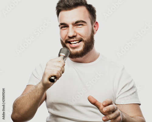 lifestyle and people concept: young man singing with microphone