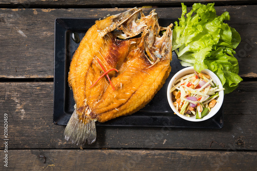 Deep fried seabass fish in black soy sauce, called Pla Krapong Tord Nam Plar Thai Food photo