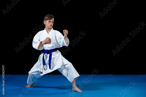 Pre-teen boy doing karate on a black background