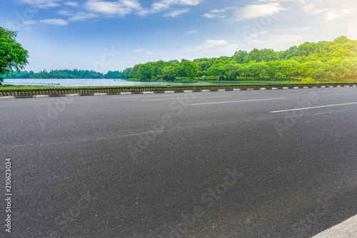 The empty asphalt road and natural landscape under the blue sky