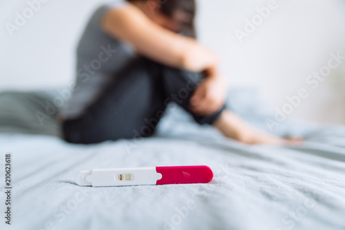 negative pregnancy test. sad woman on background photo