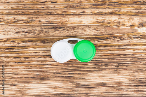 container for storing lenses lies on a dark wooden background