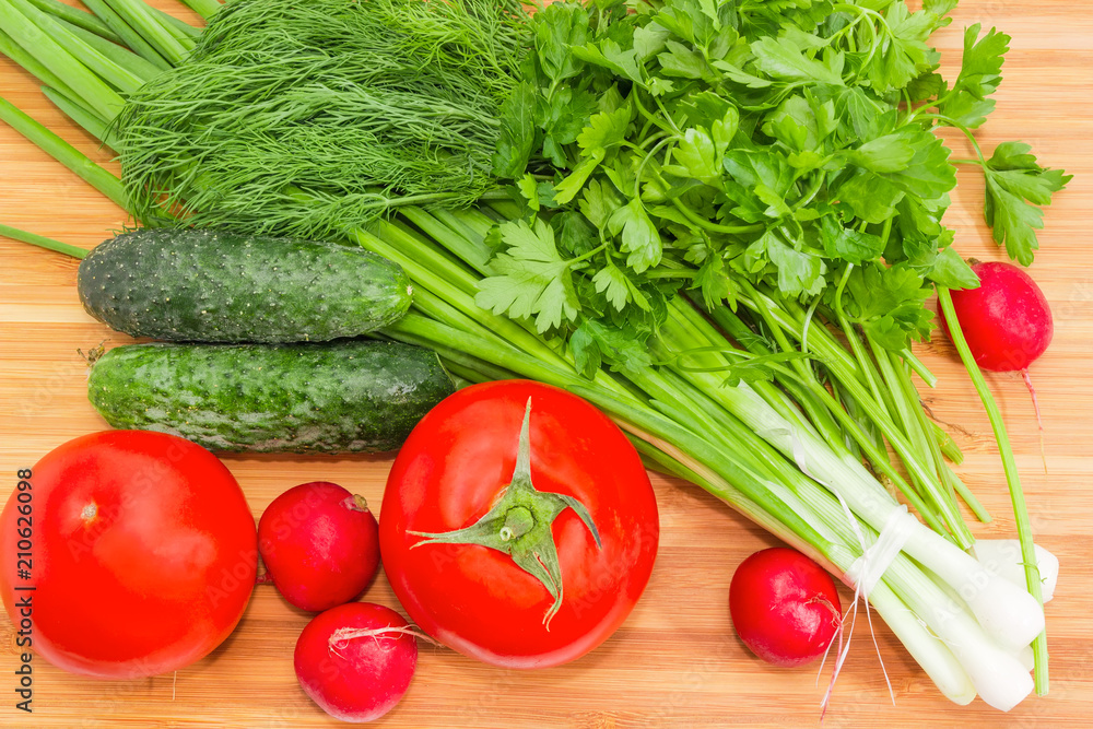 Top view of vegetables and greens on bamboo cutting board Top view of vegetables and greens on bamboo cutting board