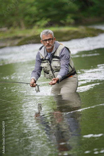 Fisherman fly-fishing in river