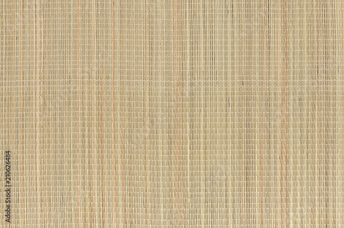 Beige natural mat of dry wicker grass as texture, background - woven bamboo straw tatami pattern for wallpaper and design.
