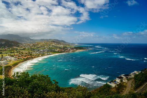 Fototapeta Naklejka Na Ścianę i Meble -  A view over St. Kitts Island with residential area and beaces on the foreground and lush green hills on the background