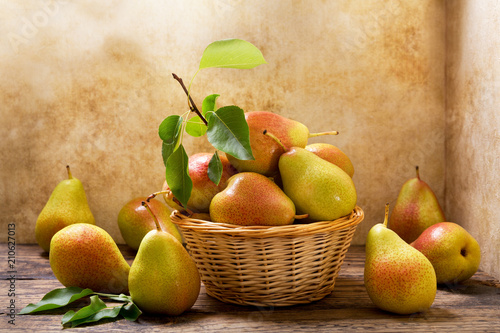 fresh pears with leaves in a basket