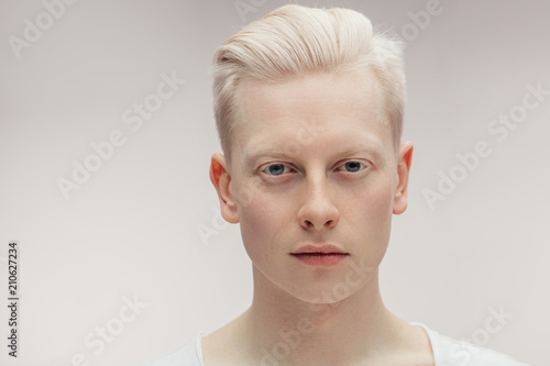 Fashion albino model man portrait isolated on white background. Stylish haircut, perfect skin. Man Beauty and Healthy Skin Care Concept photo