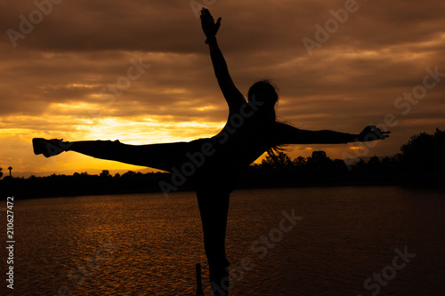 Women are playing yoga at Reservoir area with Sunset  