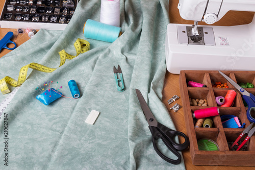Sewing machine and cloth, set of sewing accessories on table
