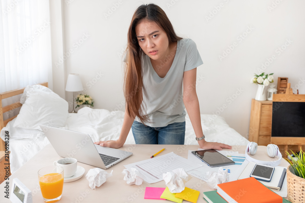 Asian woman freelancer upset with work problem with laptop on mess table.work at home concept.stress working. Asian woman freelancer upset with work problem with laptop on mess table.work at home concept.stress working.