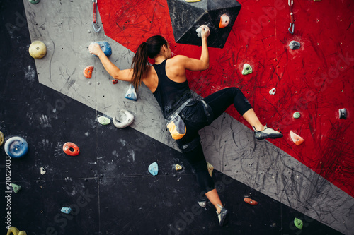 Cropped view of female rock climber wearing safety harness and climbing equipment outdoor, close-up image photo