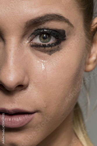 Sad crying girl looking into camera with smeared make-up