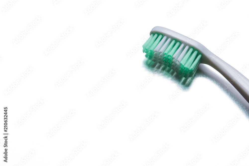 Green toothbrush on a gray background closeup Green toothbrush on a gray background closeup