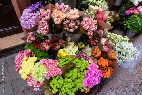 Fototapeta Naklejka Na Ścianę i Meble -  Various bouquets of flowers on a street show-window of flower shop, Italy.