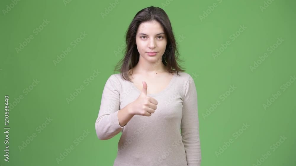 Young happy beautiful woman smiling while giving thumbs up Young happy beautiful woman smiling while giving thumbs up