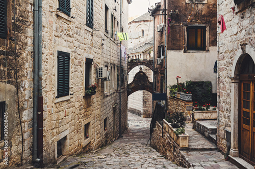 Narrow european street with old historical buildings in the ancient town Kotor in Montenegro