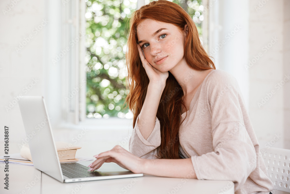 Cute pretty young redhead lady using laptop computer. Cute pretty young redhead lady using laptop computer.