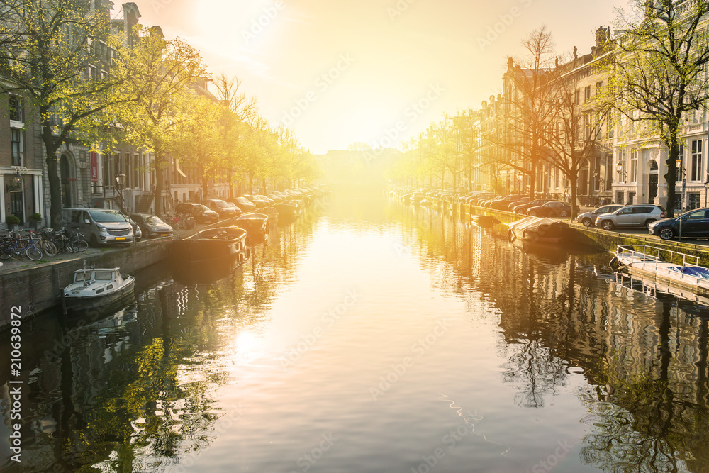 Amsterdam canal at sunset with boats