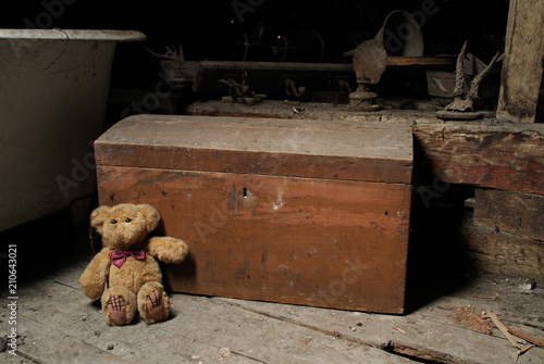 Quadro em tela Childs teddy bear and an old chest in the dusty attic space of an old house
