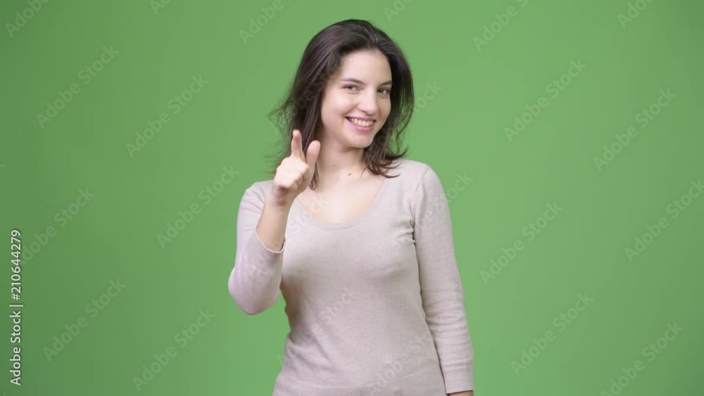 Young happy beautiful woman winking and pointing to camera Young happy beautiful woman winking and pointing to camera