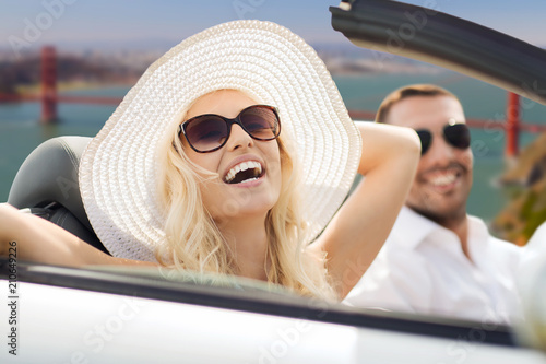 road trip, travel and people concept - happy couple driving in convertible car over golden gate bridge in san francisco bay background © Syda Productions