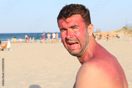 Childish looking adult crying at the beach 