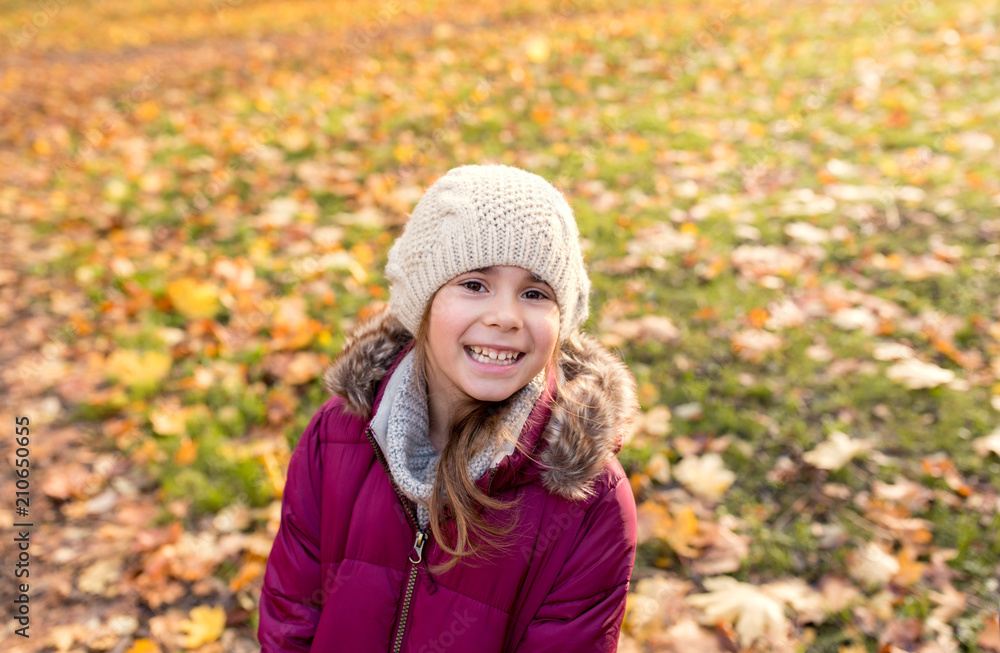 childhood, season and people concept - happy beautiful little girl at autumn park childhood, season and people concept - happy beautiful little girl at autumn park