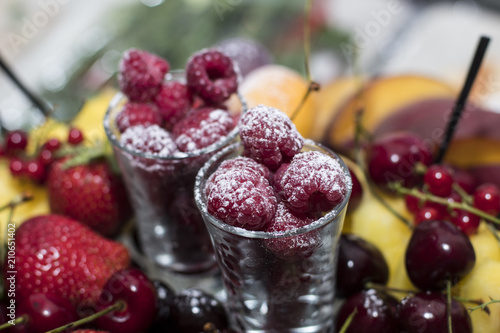 Raspberry in a glass of wine sprinkled with powdered sugar
