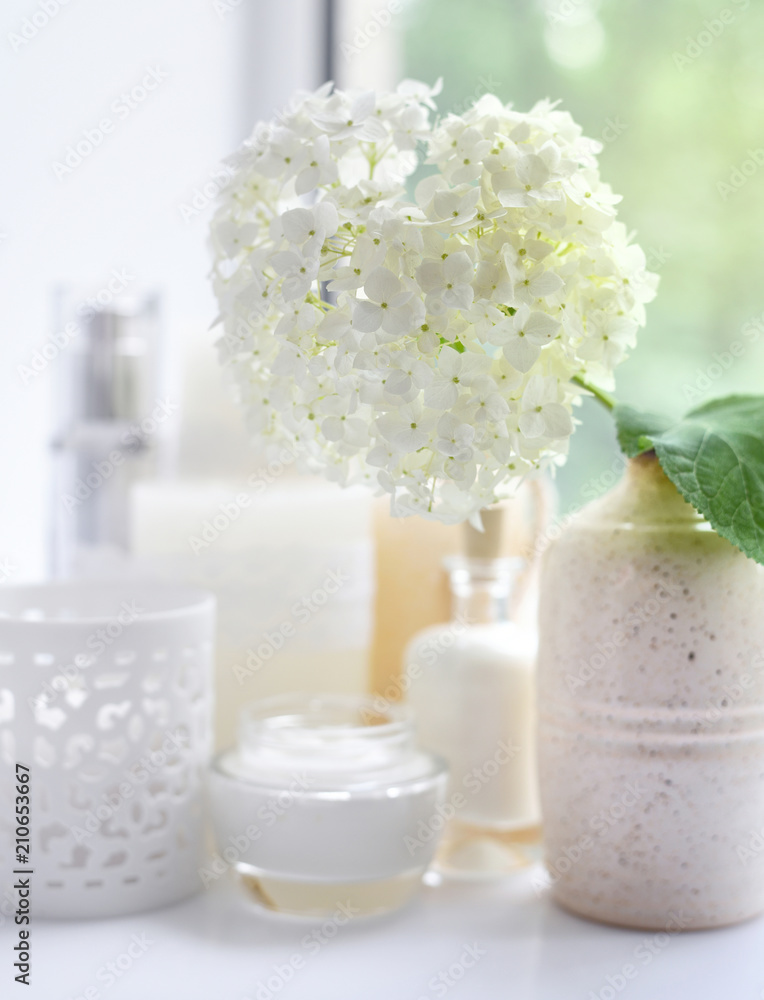 White hydrangea with spa products on a white background
