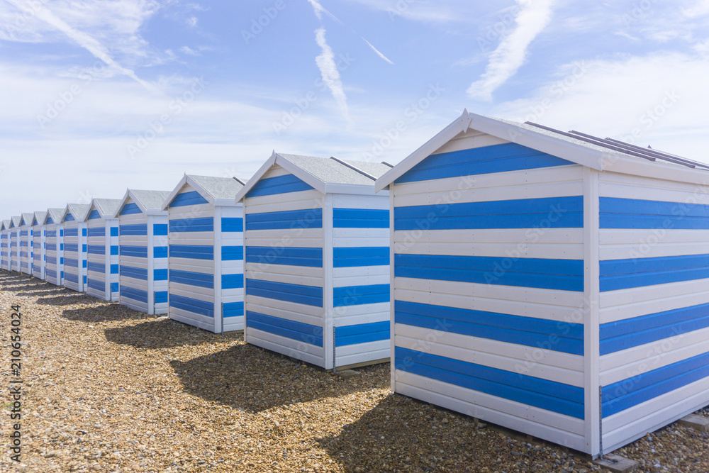 Blue and white striped beach huts at the seaside Blue and white striped beach huts at the seaside