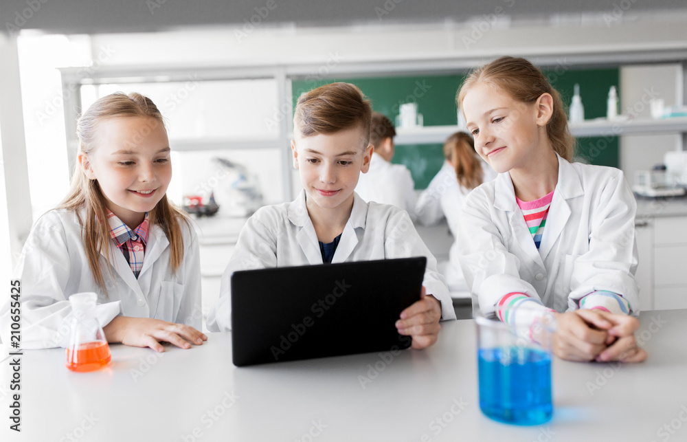 education, science and technology concept - kids with tablet pc computer studying chemistry at school laboratory education, science and technology concept - kids with tablet pc computer studying chemistry at school laboratory