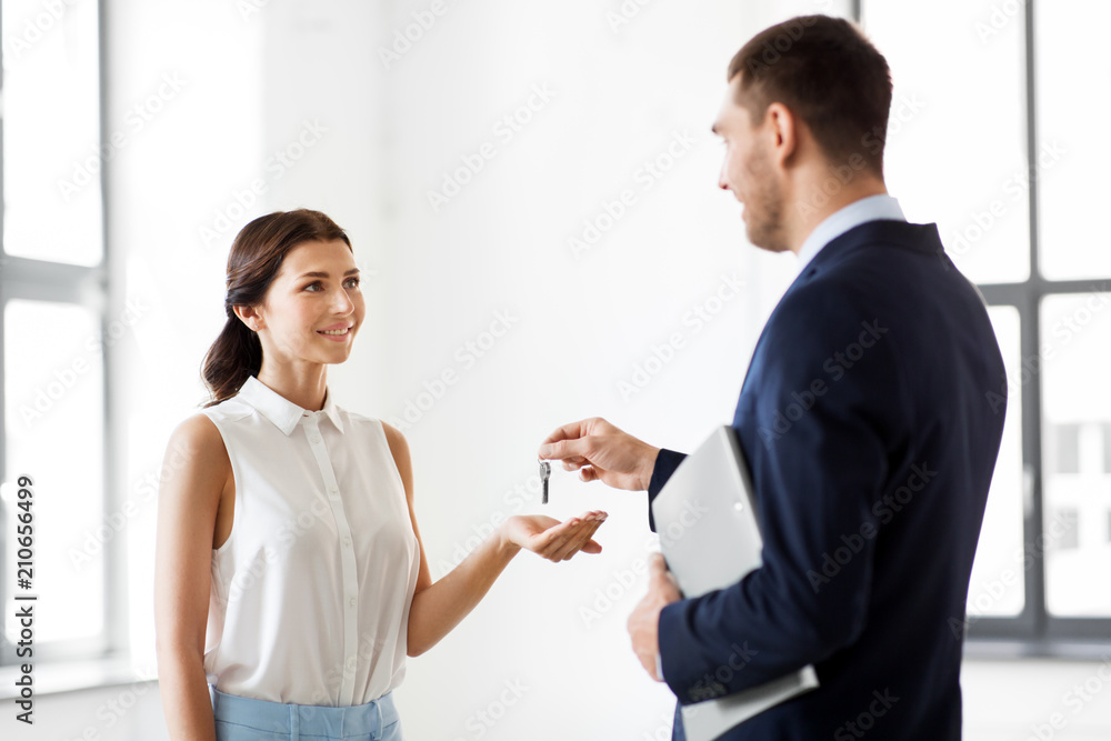 real estate business, sale and people concept - realtor giving key to customer or new office owner real estate business, sale and people concept - realtor giving key to customer or new office owner