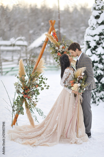 Fotografie Winter wedding European bridegroom and Asian bride
