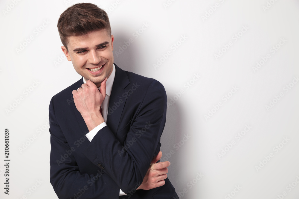 joyful and pensive young businessman looks to side joyful and pensive young businessman looks to side