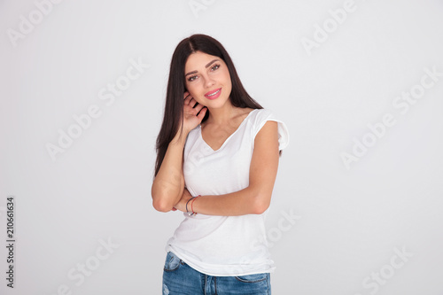 sexy casual woman in white t-shirt arranging her hair